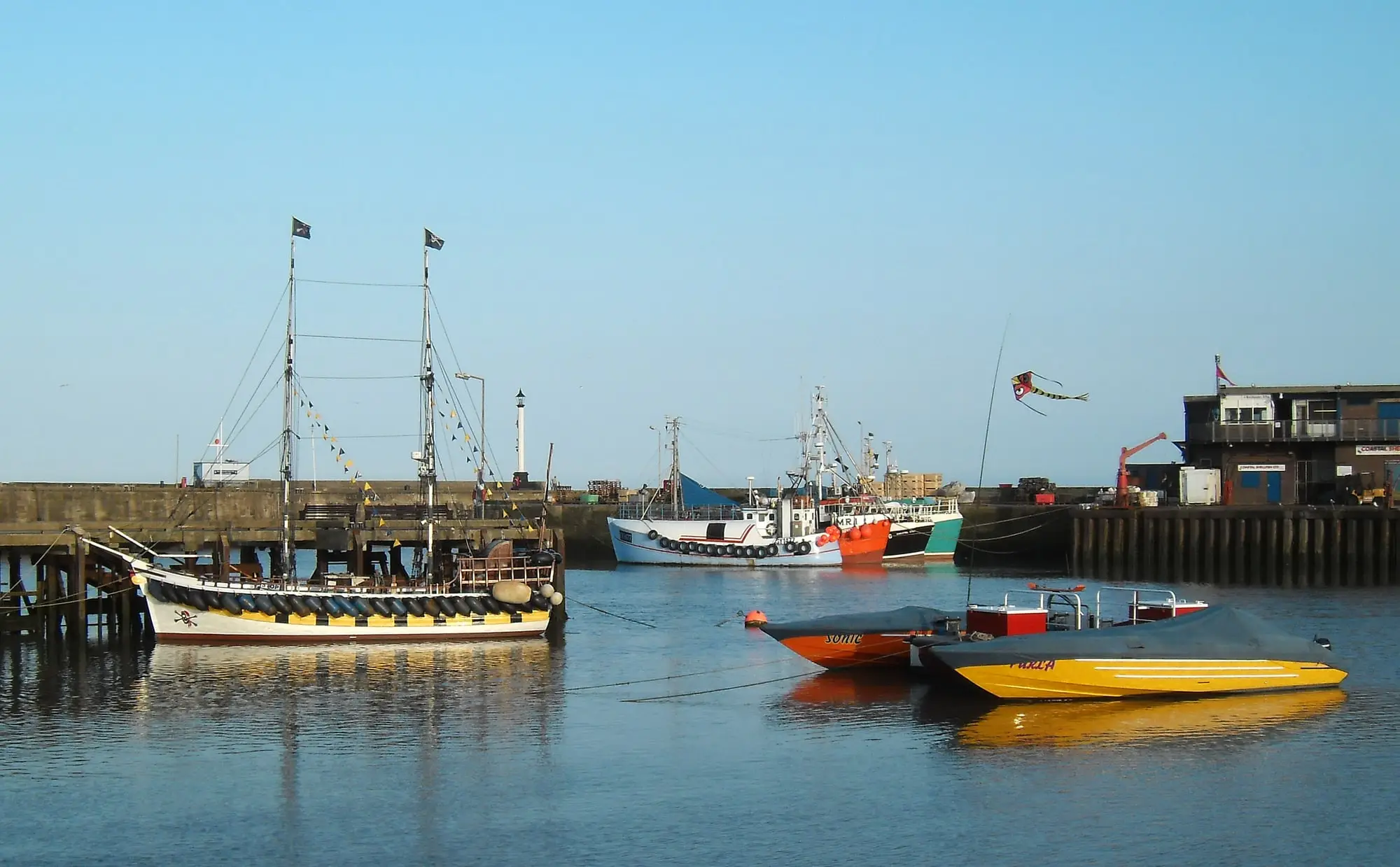 Fishing boats and pleasure craft moored in Bridlington Harbour in soft evening light