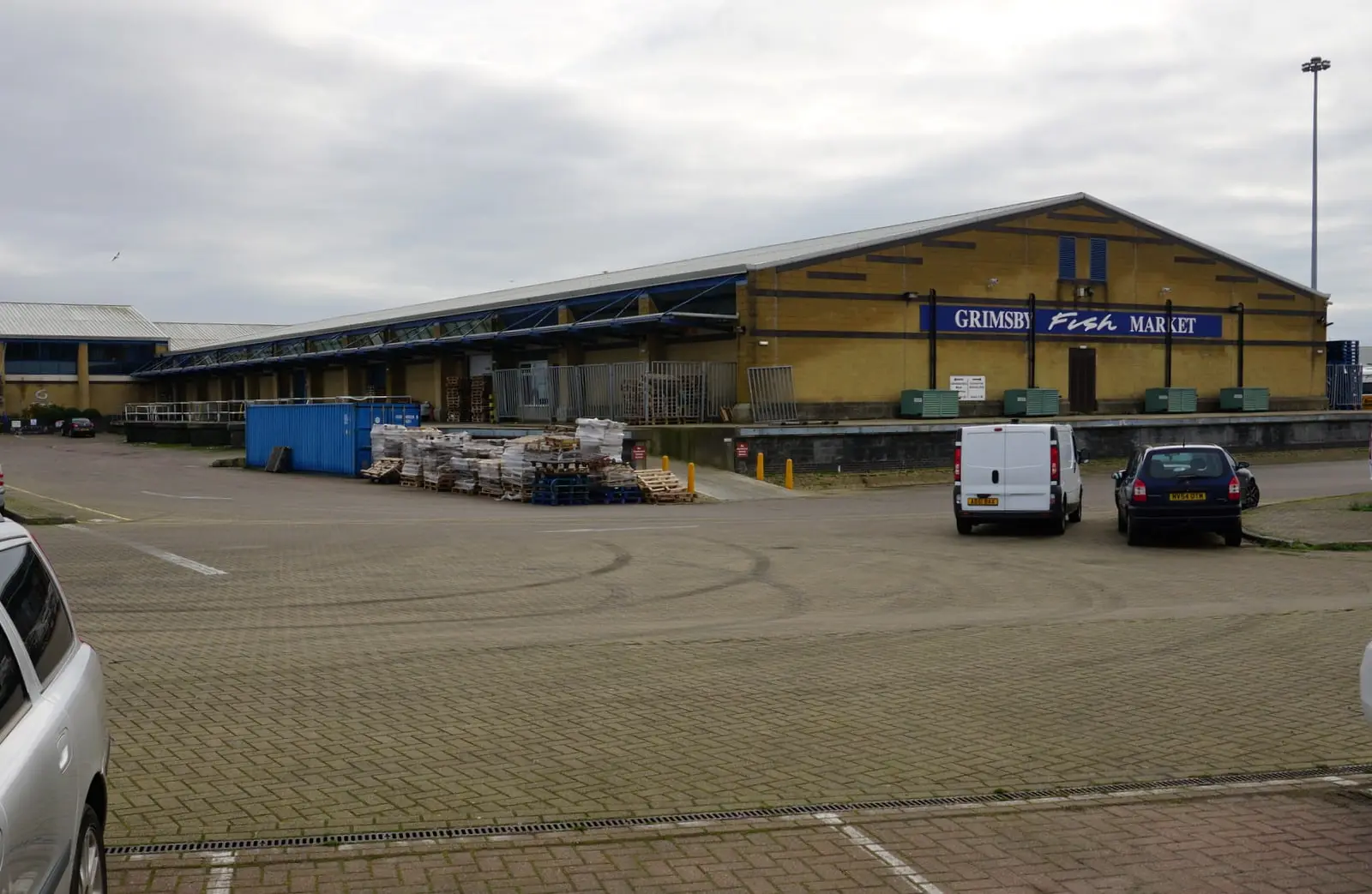 The Grimsby Fish Market building on Grimsby Docks, with pallets and a delivery van on the quayside