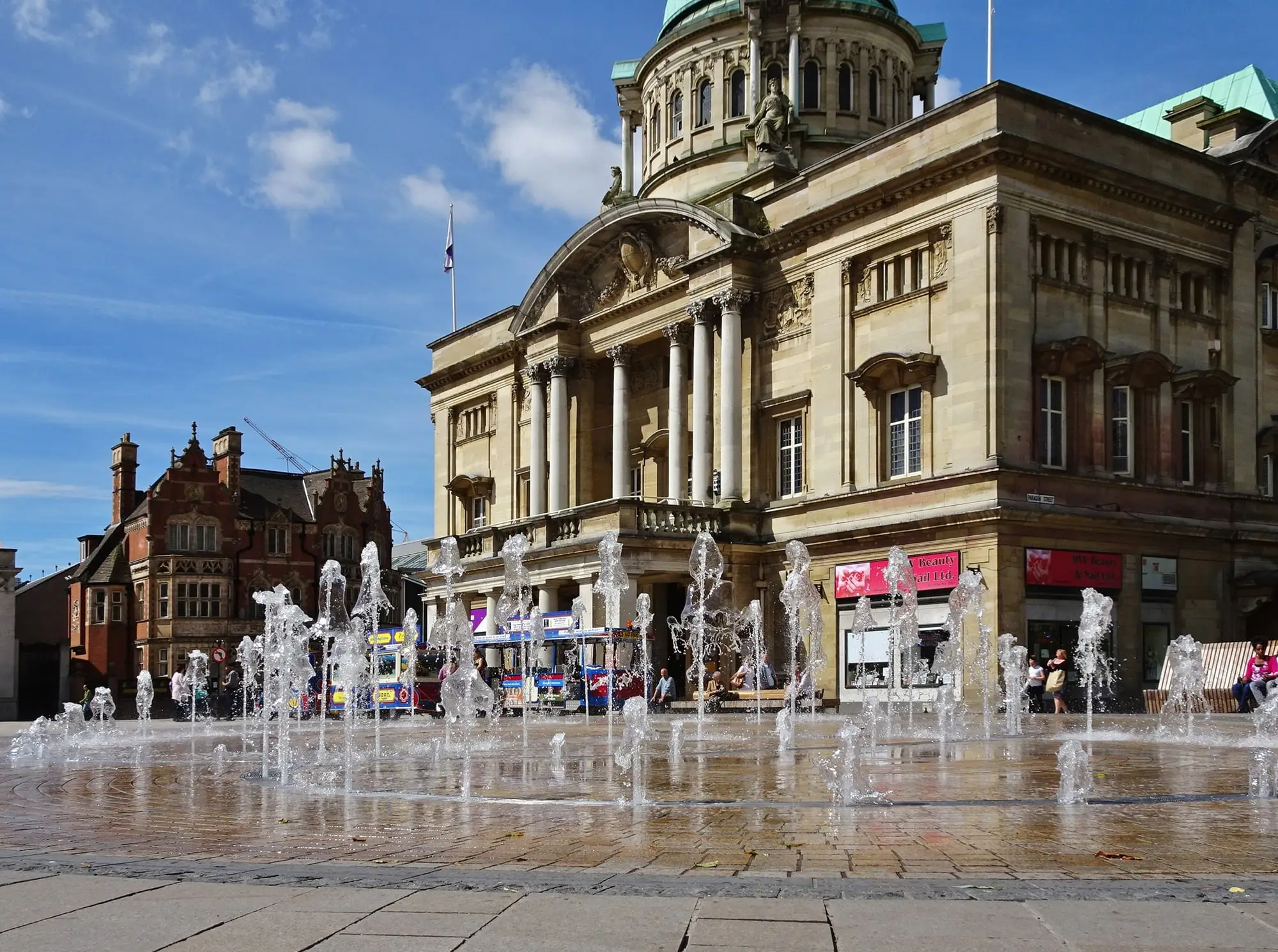 Fountains playing in Queen Victoria Square in front of Hull City Hall on a sunny day