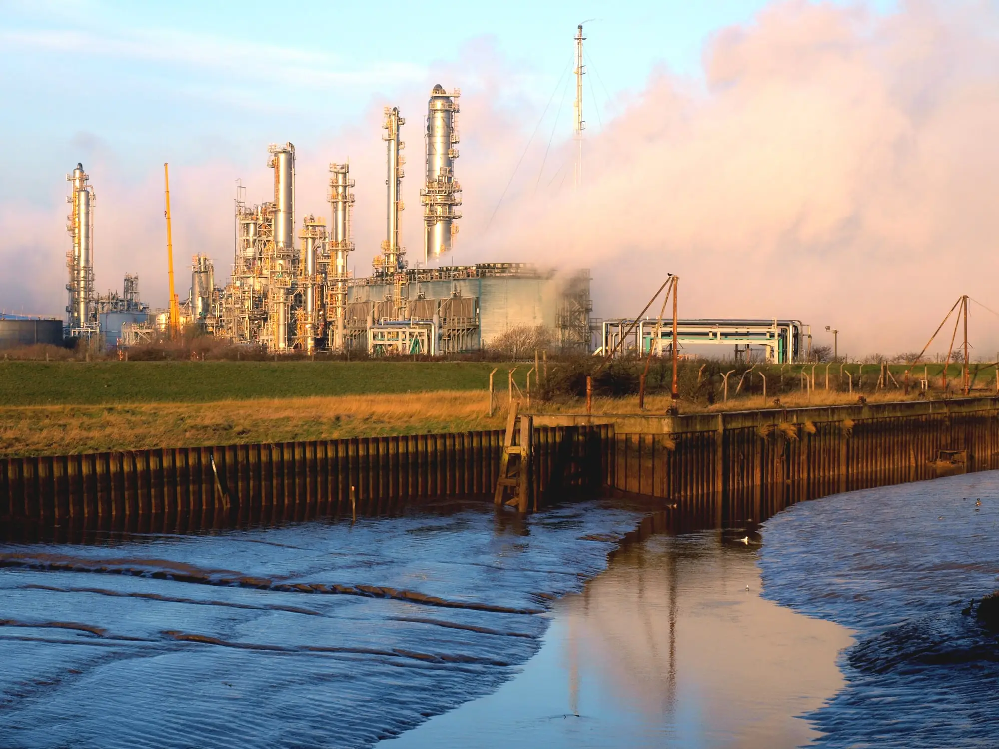 Saltend Chemicals Park near Hull at golden hour, with distillation columns and steam rising beyond the mouth of Hedon Haven