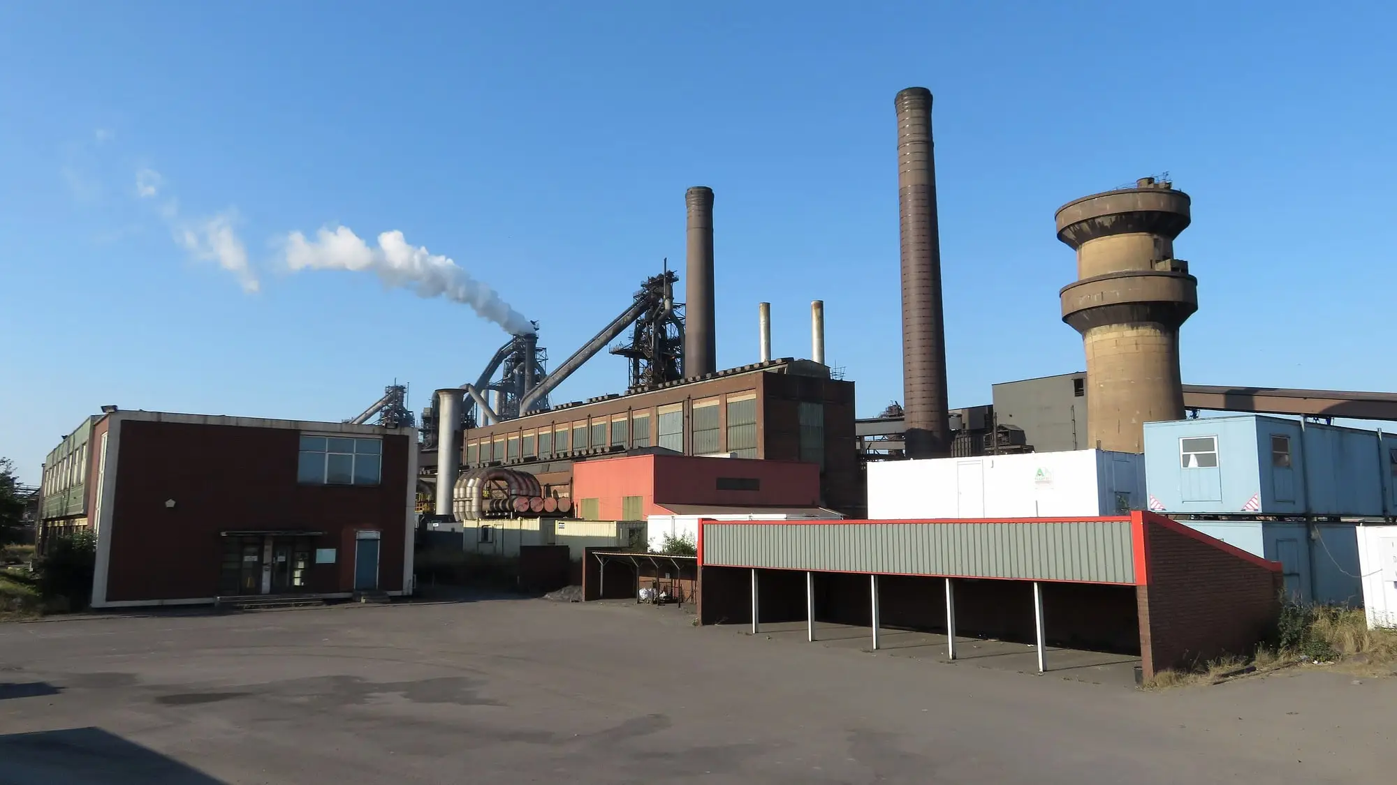 Blast furnaces and chimneys of the Scunthorpe steelworks against a blue sky